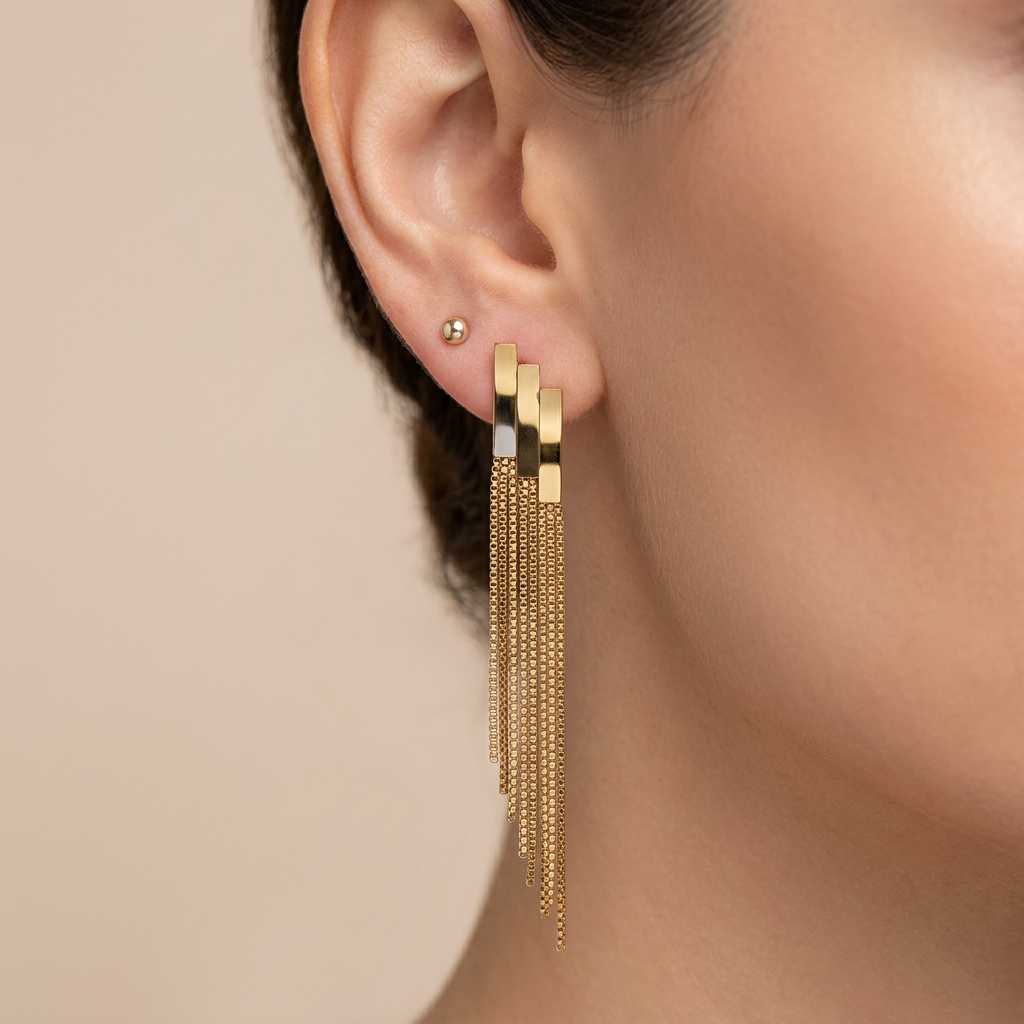 Boucle d'oreille dorée pendante à franges portée à l'oreille