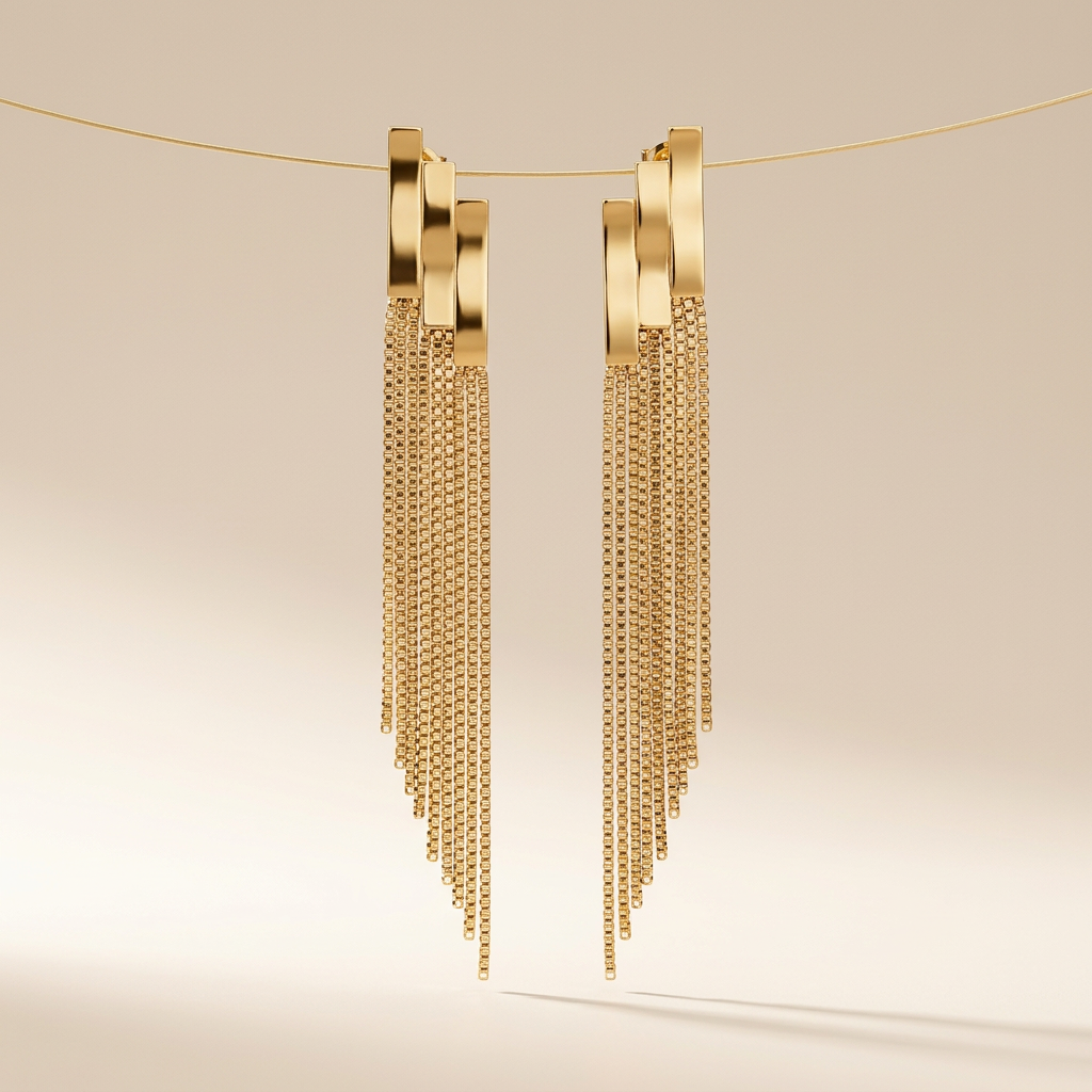 Paire de boucles d'oreilles dorées pendantes à franges de chaînettes, photo studio sur fond beige